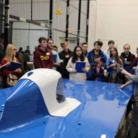 group of k-12 students looking a large senior project